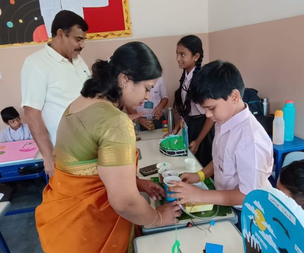 Teacher guiding students in arts and crafts for holistic development